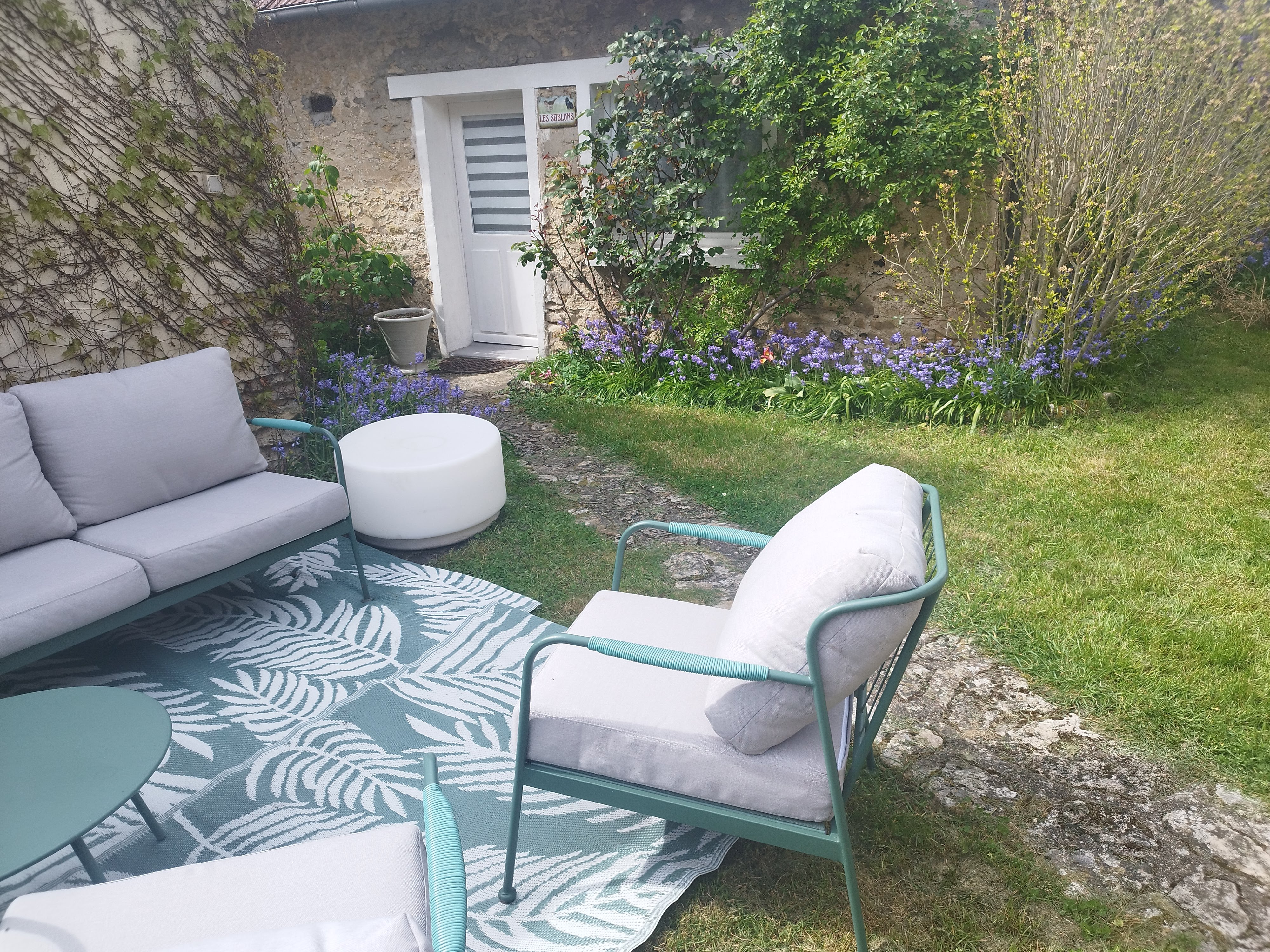 Table et chaises en fer forgé sous un arbre du jardin